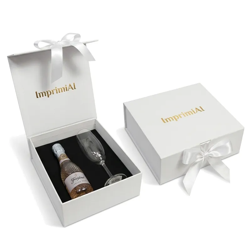 Caixa Kit Mini Espumante aberta com garrafa e taça de cristal, ao lado da caixa fechada com laço